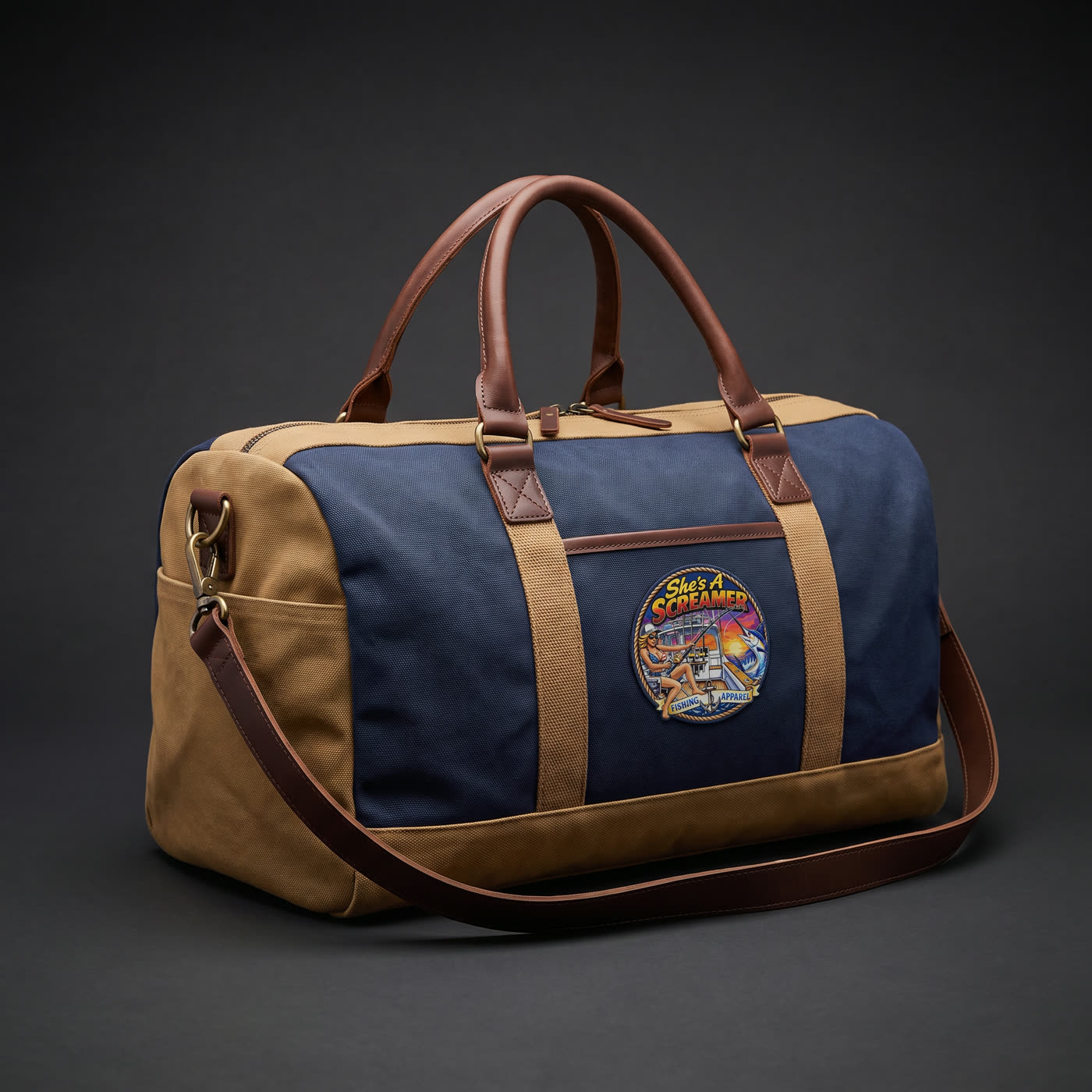 Navy and tan canvas duffle bag with a She's a Screamer logo patch on the front panel