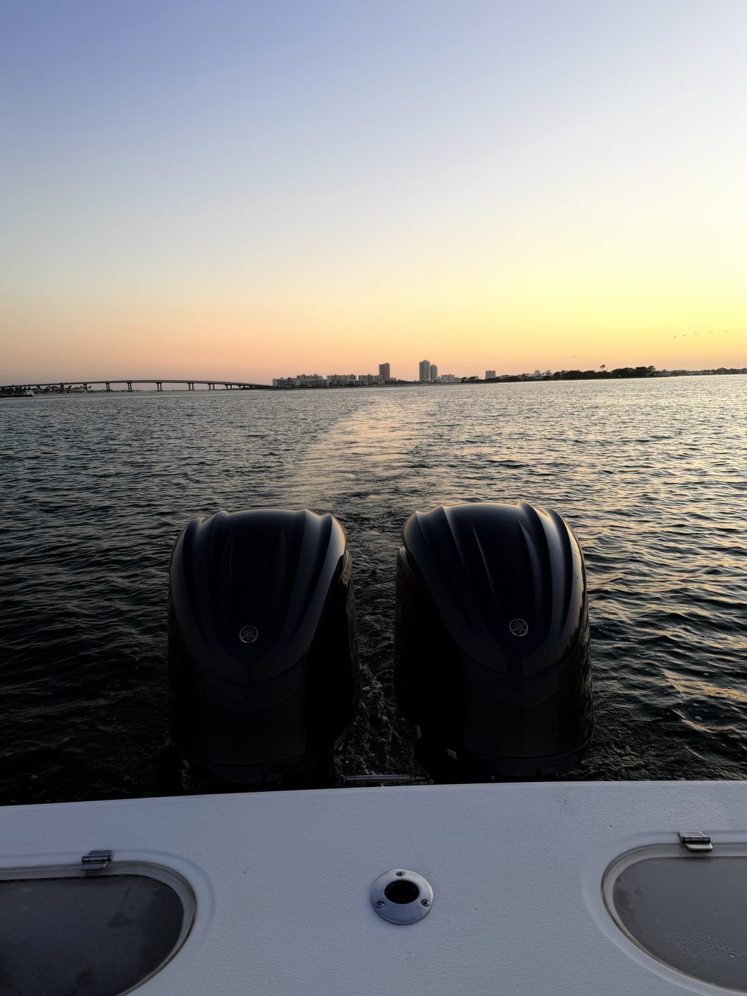 Fishing rod bent double under heavy tension over calm blue offshore water