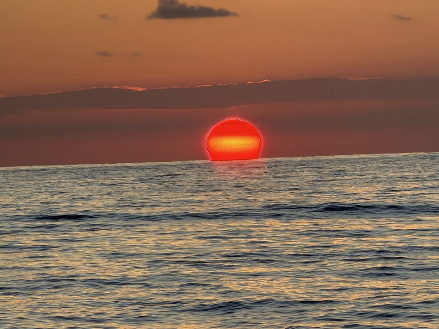 Blazing red sun setting into the Gulf horizon